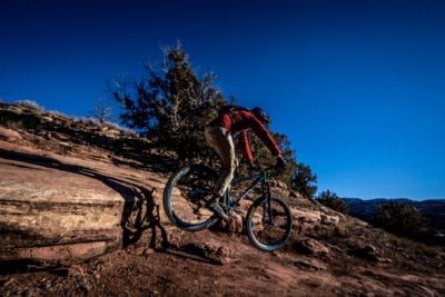 Dropping a three foot ledge on a mountain bike in the desert trail system of Kokopelli near Fruita, Colorado.
